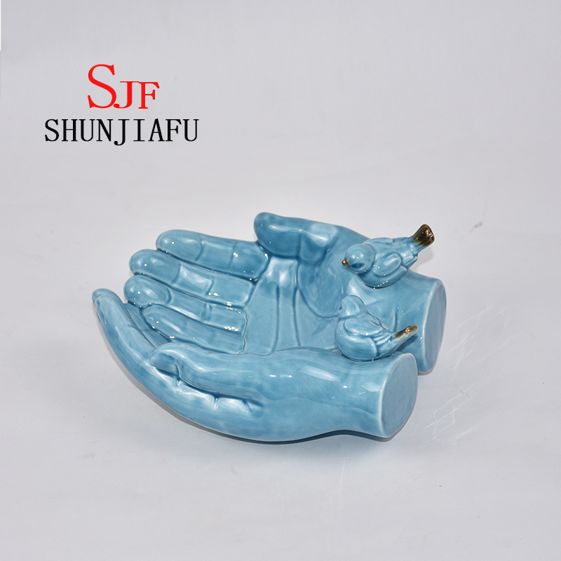 Ambas manos forman la bandeja decorativa de cer&aacute;mica para utensilios de cocina / decoraci&oacute;n del hogar