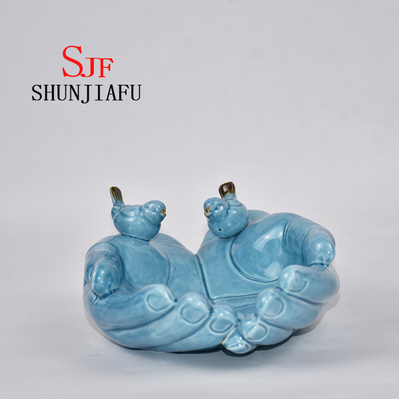 Ambas manos forman la bandeja decorativa de cer&aacute;mica para utensilios de cocina / decoraci&oacute;n del hogar