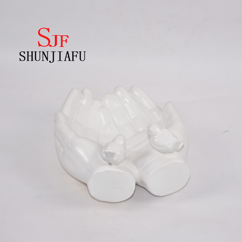 Ambas manos forman la bandeja decorativa de cer&aacute;mica para utensilios de cocina / decoraci&oacute;n del hogar