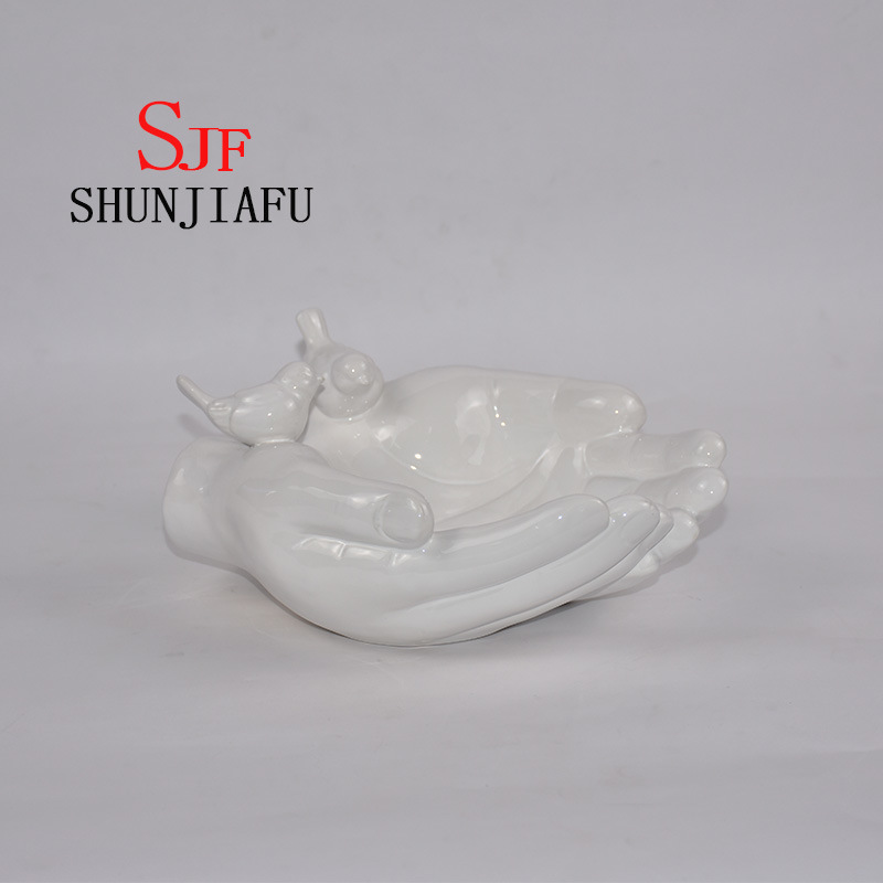 Ambas manos forman la bandeja decorativa de cer&aacute;mica para utensilios de cocina / decoraci&oacute;n del hogar