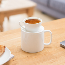 Una taza de café de cerámica blanca que se puede usar en ambos lados
